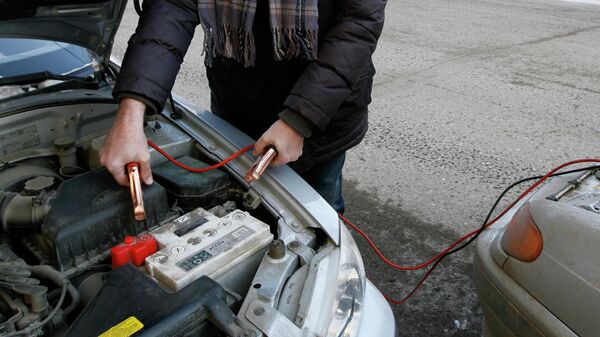 Мужчина прикуривает аккумулятор от другого автомобиля. Архивное фото - Sputnik Кыргызстан