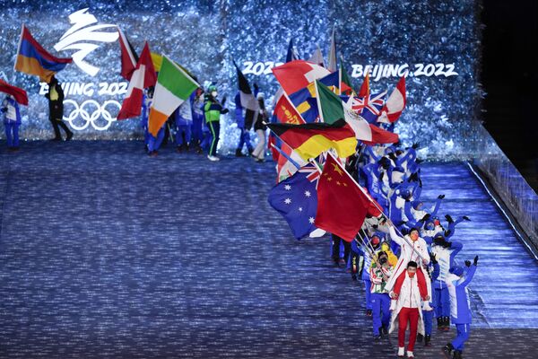 Пекинде өткөн XXIV Кышкы Олимпиада оюндарынын жабылуу салтанатында ага катышкан мамлекеттердин тууларын көтөрүп чыгып келе жатышат - Sputnik Кыргызстан