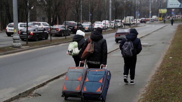 Люди с багажами идут по улице в Киеве - Sputnik Кыргызстан