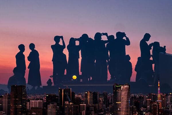 Снимок японского фотографа Каору Сугияма победил в номинации &quot;Уличная фотография&quot;. Он снял, как люди наблюдают за восходом полной Луны. - Sputnik Кыргызстан