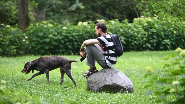Мужчина выгуливает собаку в парке. Архивное фото - Sputnik Кыргызстан