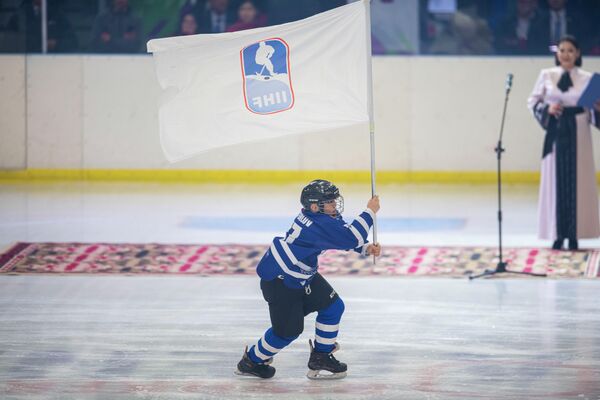 Турнир проходит на городском катке. На фото хоккеист с флагом IIHF.  - Sputnik Кыргызстан