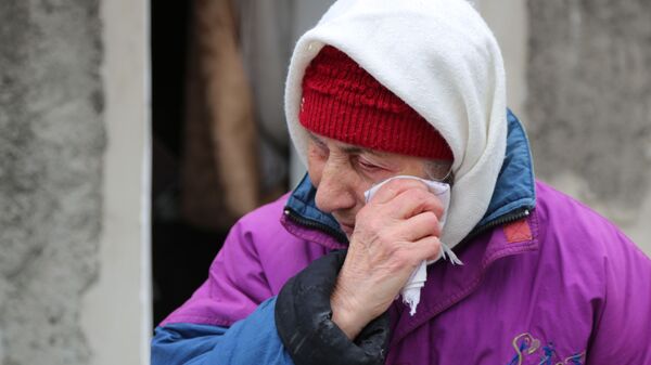 Пожилая женщина плачет около жилого дома в Киевском районе Донецка, разрушенном в результате обстрела - Sputnik Кыргызстан