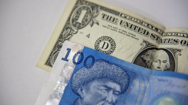 Сто сомовая купюра и одна долларовая банкнота на столе. Иллюстративное фото - Sputnik Кыргызстан