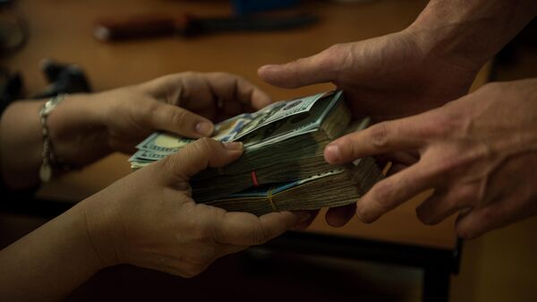 Люди передают денежные купюры сомов и долларов США. Иллюстративное фото - Sputnik Кыргызстан