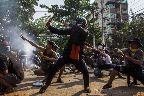 Снимок анонимного автора победил в категории &quot;Единичные фото, Юго-Восточная Азия и Океания&quot;. На фото протестующие в Янгоне (Мьянма) используют рогатки и другое самодельное оружие в столкновении с силами безопасности. Массовые протесты в Мьянме вспыхнули после того, как 1 февраля 2021 года военные устроили государственный переворот. За день до того, как была сделана эта фотография, при подавлении протестов были убиты 114 мирных жителей. - Sputnik Кыргызстан