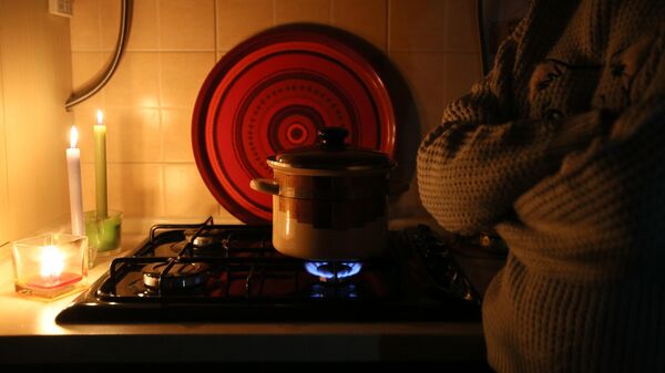 Девушка разогревает суп на газовой плите во время отключения электричества. Архивное фото  - Sputnik Кыргызстан