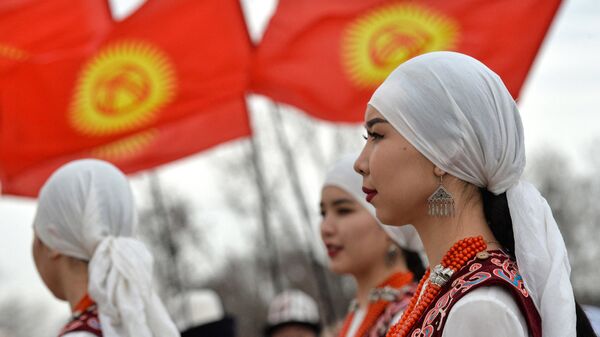 Девушки в национальной одежде на фоне флагов КР в Бишкеке. Архивное фото - Sputnik Кыргызстан