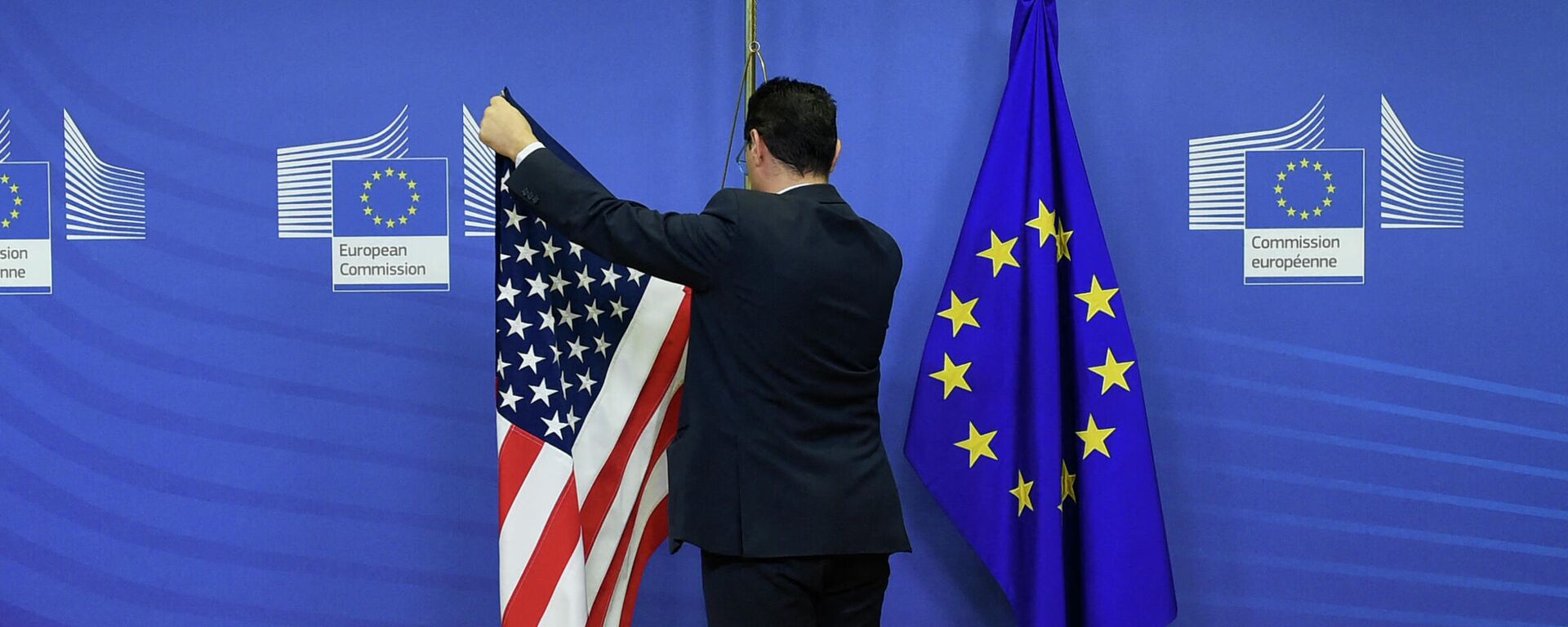 Сотрудник вывешивает флаг США рядом с флагом ЕС в штаб-квартире ЕС в Брюсселе. Архивное фото - Sputnik Кыргызстан, 1920, 15.12.2022