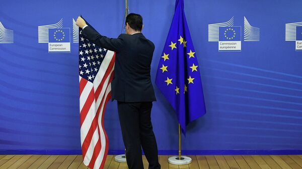 Сотрудник вывешивает флаг США рядом с флагом ЕС в штаб-квартире ЕС в Брюсселе. Архивное фото - Sputnik Кыргызстан
