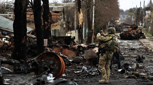 Военнослужащий снимает на телефон разрушения в Буче, Украина - Sputnik Кыргызстан