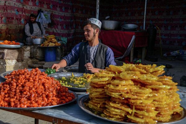 Продавец сладостей в Кандагаре (Афганистан). Пост во время Рамазана в Южной Азии соблюдают более полумиллиарда мусульман. - Sputnik Кыргызстан