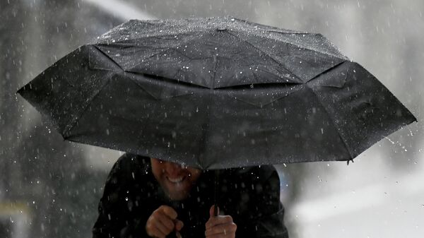 Мужчина под зонтом во время сильного дождя. Архивное фото - Sputnik Кыргызстан