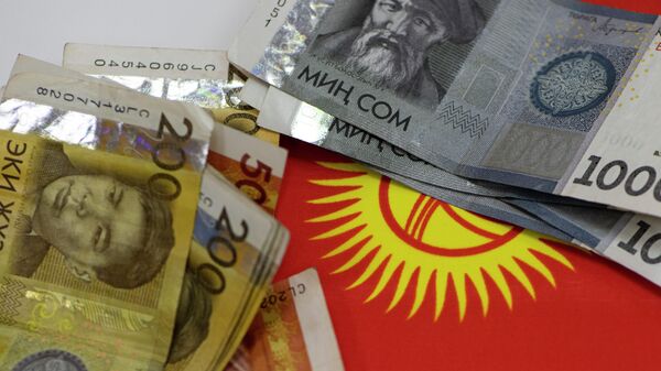 Сомовые купюры на фоне флага КР. Архивное фото - Sputnik Кыргызстан