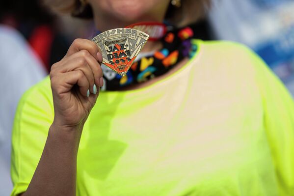 Девушка демонстрирует медаль участника массового забега  - Sputnik Кыргызстан
