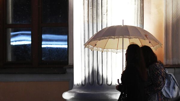 Девушки идут под зонтом во время дождя. Архивное фото - Sputnik Кыргызстан