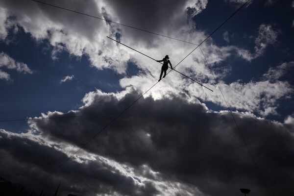Французская канатоходка во время 20-метрового хайлайна (хождение на большой высоте по натянутой стропе) на представлении в Веве (Швейцария) - Sputnik Кыргызстан