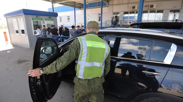 Сотрудник пограничной службы во время осмотра автомобиля. Архивное фото - Sputnik Кыргызстан
