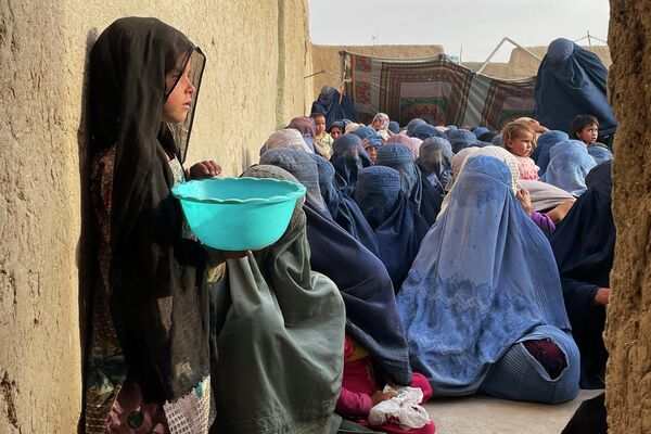 Люди ждут раздачи продовольственных пожертвований во время священного месяца Рамадан в Кандагаре (Афганистан) - Sputnik Кыргызстан