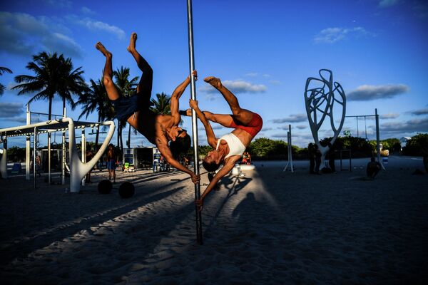 Спортсмены занимаются акробатикой с шестом на песке в Майами-Бич, США - Sputnik Кыргызстан