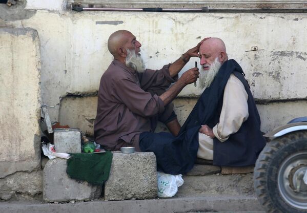 Мужчина бреется у уличного парикмахера в Пешаваре (Пакистан) - Sputnik Кыргызстан