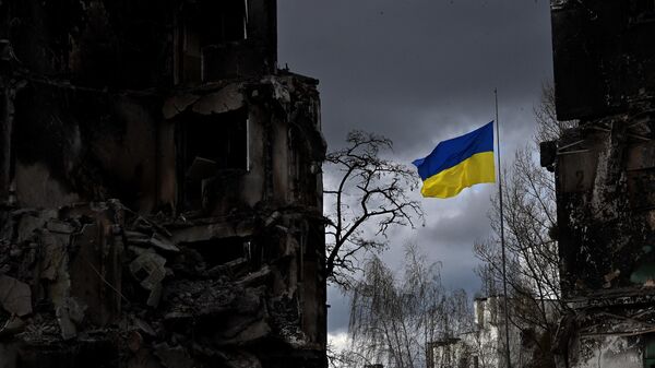 Украинский флаг развевается между разрушенными зданиями. Архивное фото - Sputnik Кыргызстан
