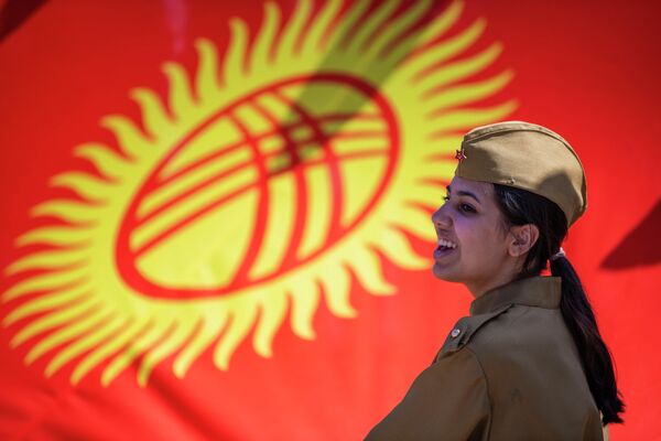 Участница шествия на фоне флага Кыргызстана - Sputnik Кыргызстан