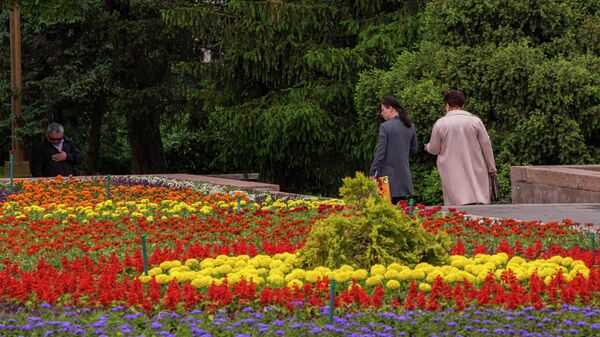 Люди у цветочных клумбы на площади Ала-Тоо в Бишкеке. Архивное фото - Sputnik Кыргызстан