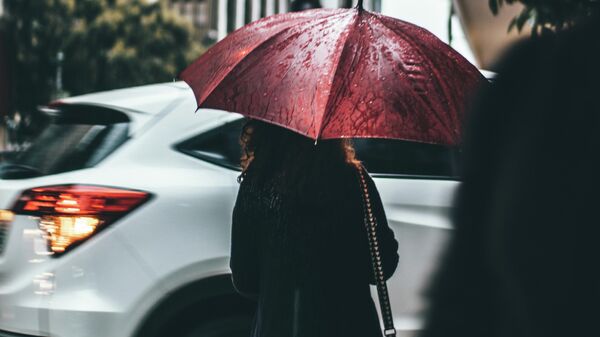 Девушка идет под зонтом во время дождя. Архивное фото - Sputnik Кыргызстан