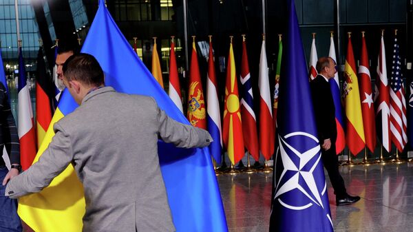 Протоколдун мүчөсү НАТОнун Брюсселдеги штаб-квартирасында Украинанын желегин орнотуп жатат. Архив - Sputnik Кыргызстан