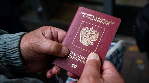 Мужчина держит в руках паспорт РФ. Архивное фото - Sputnik Кыргызстан