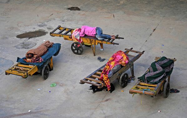 Носильщики спят на своих ручных тележках на вокзале в Нью-Дели (Индия) - Sputnik Кыргызстан