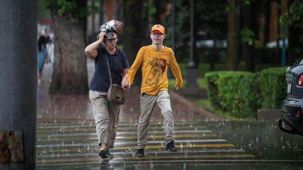 Люди на улице в Бишкеке во время дождя. Архивное фото - Sputnik Кыргызстан