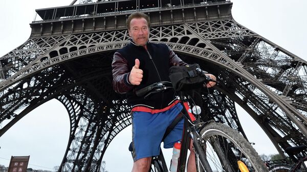 Американский актер и политик Арнольд Шварценеггер позирует под Эйфелевой башней после поездки на велосипеде по Парижу - Sputnik Кыргызстан