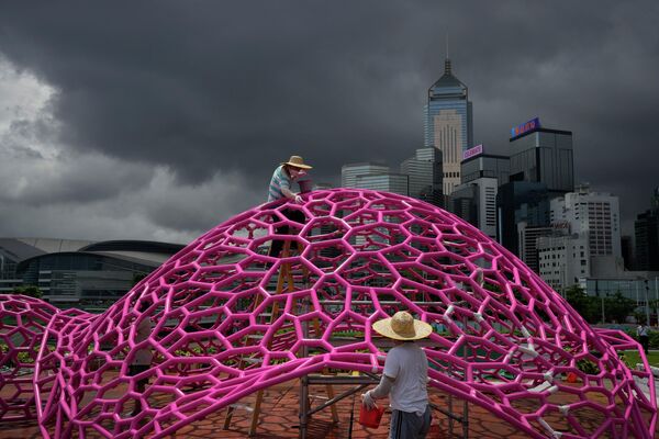 Рабочие красят художественную инсталляцию на набережной в Гонконге, изготовленную в честь 25-й годовщины передачи Гонконга Китаю - Sputnik Кыргызстан