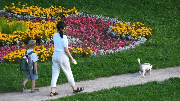 Женщина с мальчиком гуляют с собакой в парке. Архивное фото - Sputnik Кыргызстан