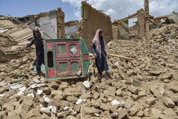 Мужчины ищут свои вещи среди руин дома, пострадавшего в результате землетрясения в районе Бермал, провинция Пактика (Афганистан). Мощное землетрясение магнитудой 6,1 балла произошло в ночь на 22 июня. Сообщалось о сильных разрушениях в приграничных с Пакистаном провинциях Пактика и Хост. Местные СМИ сообщали, что число погибших достигло 1,1 тысячи, пострадали свыше 1650 человек. - Sputnik Кыргызстан