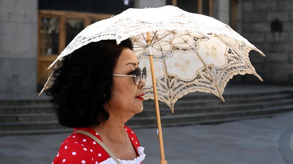 Женщина на улице с зонтом во время жары - Sputnik Кыргызстан