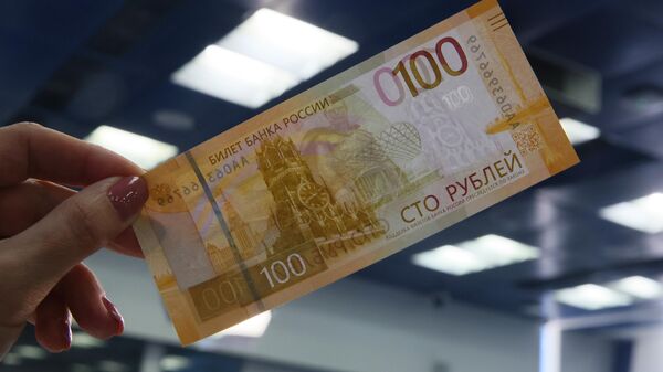 Модернизированная 100-рублевая банкнота во время ее презентации в пресс-центре ТАСС в Москве. - Sputnik Кыргызстан