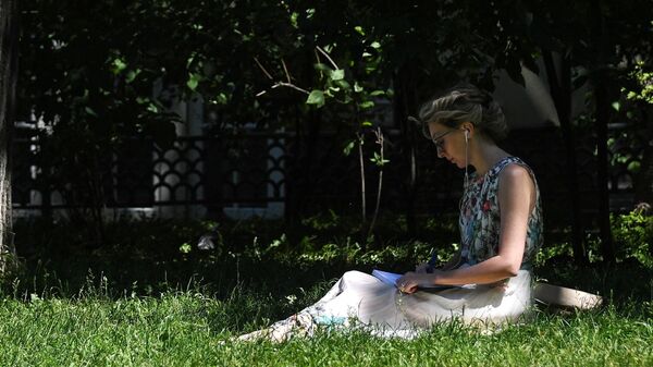 Женщина читает книгу под деревом в парке - Sputnik Кыргызстан