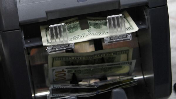 Счетная машинка пересчитывает доллары США. Архивное фото - Sputnik Кыргызстан