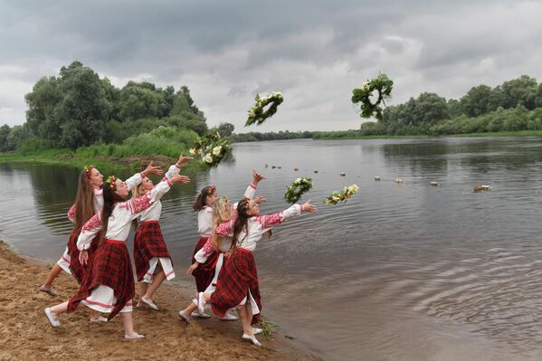 Белорусские женщины в национальных костюмах бросают венки в реку Березину в День Ивана Купалы. Это старинный праздник, посвященный летнему солнцестоянию. - Sputnik Кыргызстан