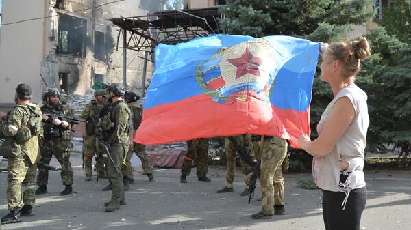 Женщина с флагом ЛНР на фоне военных у здания администрации в Лисичанске.  - Sputnik Кыргызстан