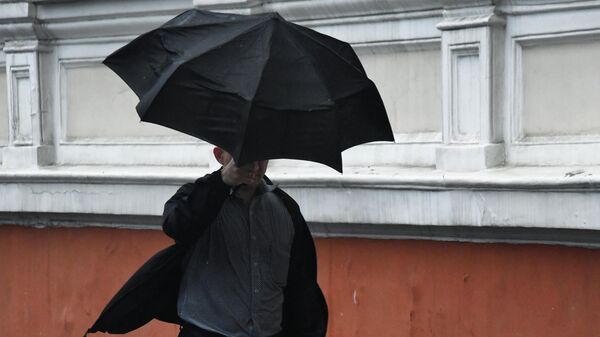 Мужчина с зонтом во время дождя  - Sputnik Кыргызстан