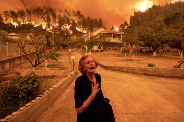 Третье место досталось Константиносу Цакадилису из Греции за фото пожилой женщины, спасающейся от лесных пожаров на острове Эвия - Sputnik Кыргызстан