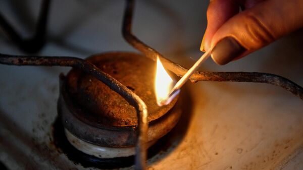 Женщина зажигает конфорку газовой плиты. Архивное фото - Sputnik Кыргызстан