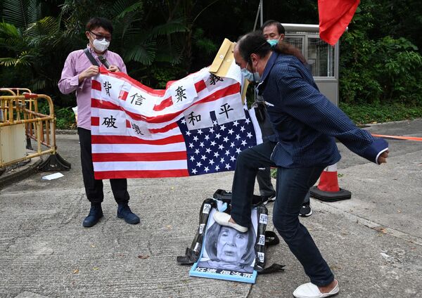 Протестующий топчет портрет спикера Палаты представителей Конгресса США Нэнси Пелоси на митинге возле американского консульства в Гонконге - Sputnik Кыргызстан