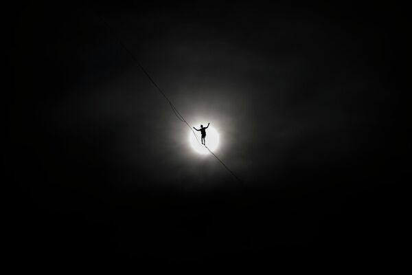 Французский канатоходец Натан Полен идет по слэклайну длиной 950 метров над Женевским озером во время мероприятия, посвященного Национальному дню Швейцарии - Sputnik Кыргызстан