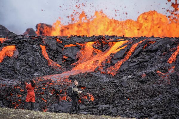 Люди наблюдают за потоками лавы на вулкане Фаградальсфьялль в Исландии - Sputnik Кыргызстан