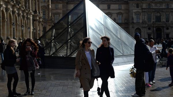 Девушки у стеклянной пирамиды Лувра во дворе Наполеона в Париже. Архивное фото - Sputnik Кыргызстан